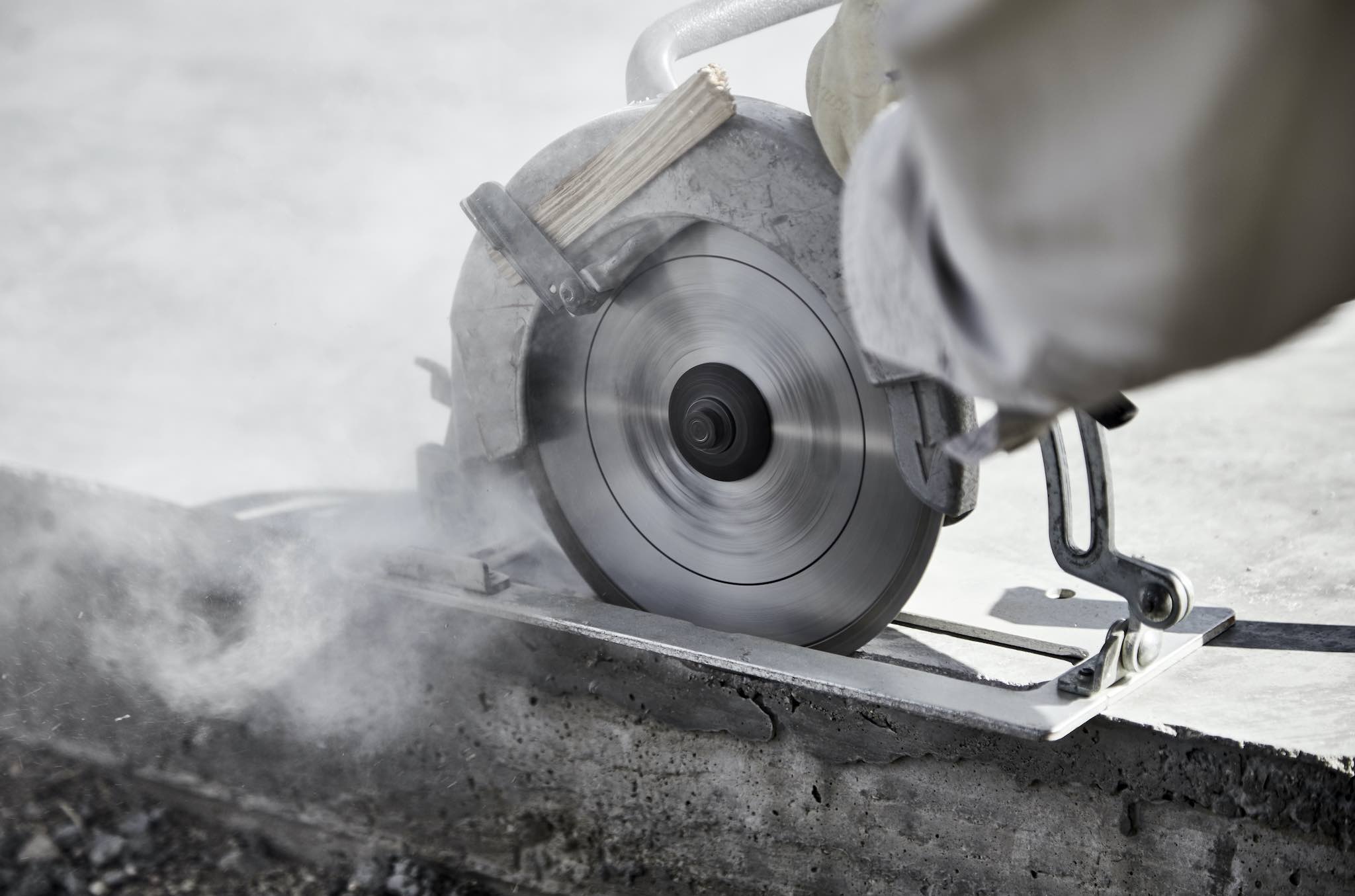 Close up of a circular saw cutting a concrete slab